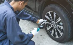 Mechanic checking tyre pressure on car tyre thumbnail